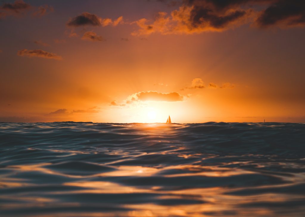 sunset with sailboat in background